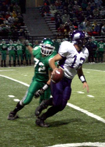 A High School Quarter Back scrambling with the def - This picture was taken at night using my Canon Digital Rebel XT with a 500mm  f 1.8 lens.  I was using an ISO of 1600.  I do not use a flash because I think it will be distracting to the players.  I tried to capture the action and the emotion of the game.  It was not a closegame but the quarter back was trying to make something happen.    Comments appreciated.