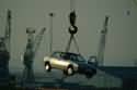 Car on hook  - This car is at a scrap yard.