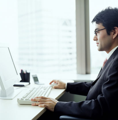Computer - Person working on his desktop computer at his work place