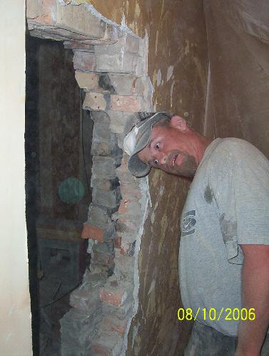 Orb - This is a photo of my brother, after he just cut a whole through the brick wall, leading to an addition. He was being silly, but after I saw the photo, there was an orb....and it looks like he is staring strangely at it. My brother is so goofy.