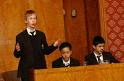 debating - you can see a boy debating in the picture and its happening in a school