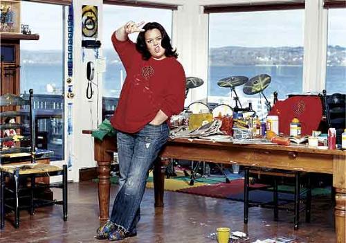 Rosie O&#039;Donell in her studio. - I love this photo of Rosie. When I imagine the Rosie that I think I know. This is her. The woman on TV is acting a part. The view is spectacular. The studio&#039;s a mess yet fabulous. Did you notice the drumset in the corner? Rosie making the "peace out" sign. She looks happy. What a life...sigh.