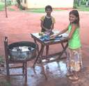 Hand Washing - 2 kids washing their clothes by hand.