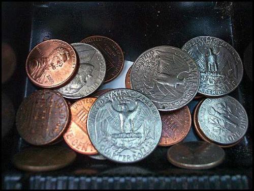 Money - A group of coins in a tray. American money with Quarters, pennies, nickels and dimes.