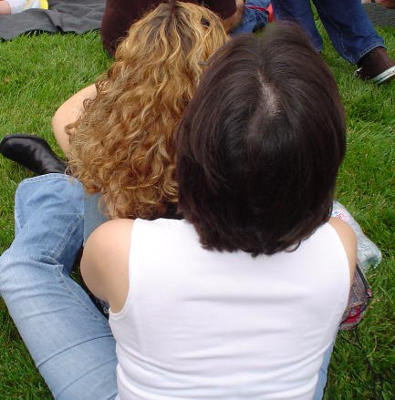 Hug - Two women watching a parade.