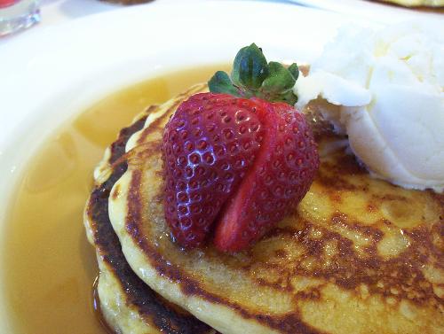 pancake - with strawberries ,whippe cream ad syrup.