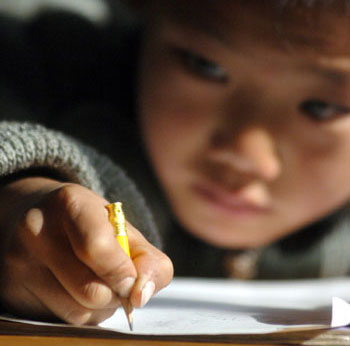 Free Education - A picture reflecting a young boy learning how to read and write in school. 