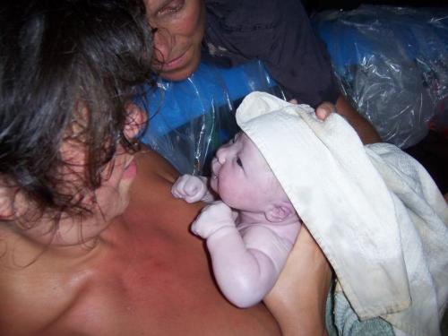birth - this is my grandaughter at 4 minutes old, after being pulled out of her pool of water by her mom and dad, and finally meeting them eye to eye.