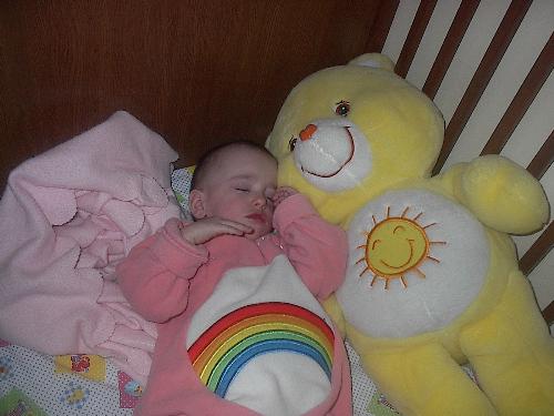 care bear - baby sleeping in care bear outfit with her huge funshine bear.