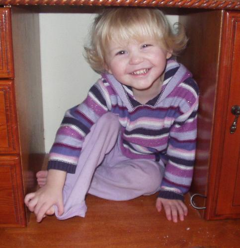 Olivia being very cheeky - This is my 2 year old daughter hiding in a gap where my stereo used to go. She knows she is being naughty really, but I couldn't help taking a shot of her.