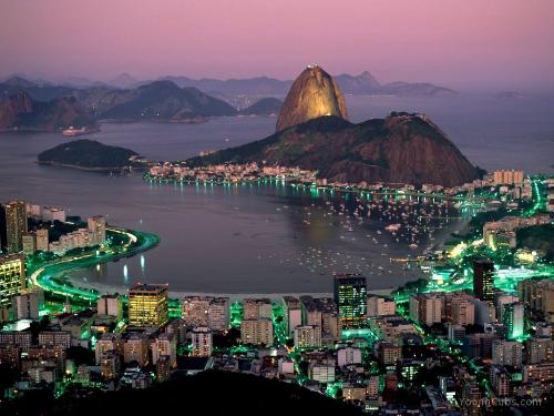 Sugar Loaf Mountain, Rio De Janeiro, Brazil - Sugarloaf Mountain (in Portuguese, Pão de Açúcar), is a peak situated in Rio de Janeiro, Brazil, from the mouth of Guanabara Bay on a peninsula that sticks out into the Atlantic Ocean. Rising 396 meters (1,300 ft) above sea-level, its name is said to refer to its resemblance to the traditional shape of concentrated refined loaf sugar. This may, however, be a folk-etymology, since it is believed by some that the name actually derives from Pau-nh-acuqua (“high hill”) in the Tupi-Guarani language, as used by the indigenous Tamoios.  The mountain is only one of several monolithic morros of granite and quartz that rise straight from the water's edge around Rio de Janeiro. A glass-paneled cablecar (in popular Portuguese, bondinho - more properly called teleférico), capable of holding 75 passengers, runs along a 1400-metre route between the peaks of Babilônia and Urca every half hour. The original cablecar line was built in 1912. So familiar is this peak, the mere sight of it in a film is sufficient to establish the setting as Rio.