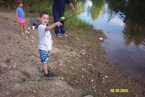 My son fishing - This is my son with his first fish.  I'm not sure that you can see the fish though.