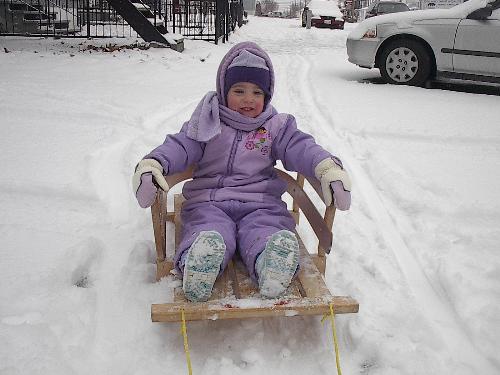 playing in snow - young child playing in the snow and going for a sled ride.