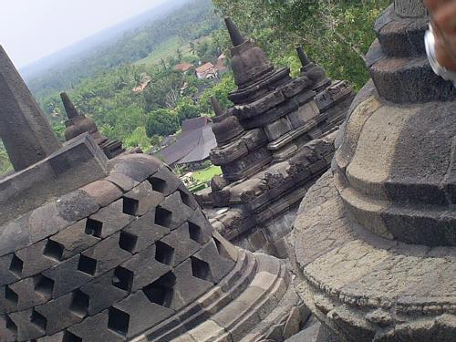 Borobudur in Indonesia - Borobudur is a ninth century Buddhist Mahayana monument in Central Java, Indonesia. The monument comprises six square platforms topped by three circular platforms, and is decorated with 2,672 relief panels and 504 Buddha statues.[1] A main dome is located at the center of the top platform. It is surrounded by seventy-two perforated stupas, each containing one sitting Buddha statue.