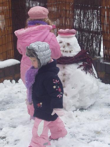 girls and the snowman - my girls standing next to their snowman