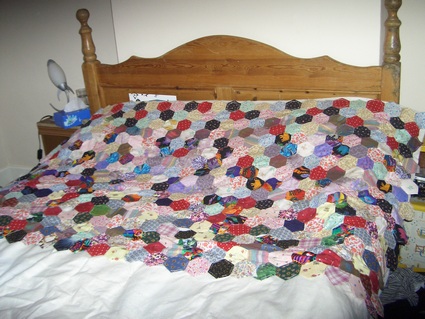 large patchwork handmade quilt in progress. - I decided to make some patches my mother left me into a big window sill cover, and I ended up making a double quilt, it's nearly halfway done now but will probably take me years to finish. It will be worth it when it is though.