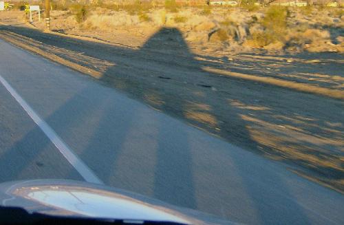 Shadow Car - Photo of a shadow cast by my car with the sun behind us. The angle of the sun caused the wheel shadows to lengthen while the body of the car compressed giving the shadow the look of a UFO.
