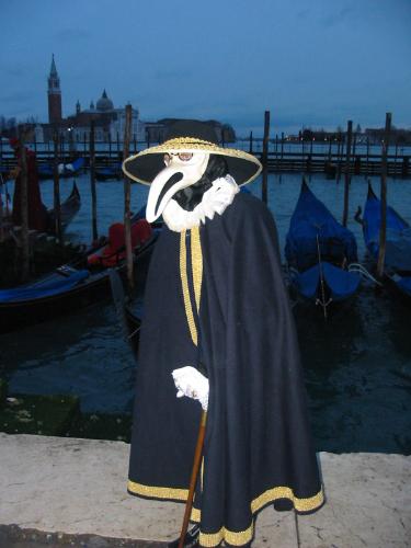 Costumed Person At Carnivale in Venice Italy - This is the typical scene at Carnivale in Venice Italy. This picture even shows the waters of the Grand Canal equipped with gondolas.