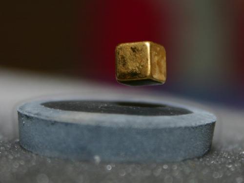 Magnets and superconductors - This is a photo of a cubical magnet levitating over a superconduting material.