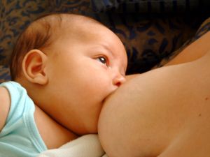 lactation - A happy baby eating and looking up at her mother