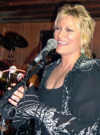 Joan performing - That's me onstage. My friend Gail was playing photographer that night and would make funny faces at us before taking a picture. I couldn't help but laugh. Hard to sing while you're laughing!