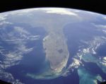 Florida - Florida is situated mostly on a large peninsula between the Gulf of Mexico, the Atlantic Ocean, and the Straits of Florida. It extends to the northwest into a panhandle, extending along the northern Gulf of Mexico. It is bordered on the north by the states of Georgia and Alabama, and on the west, at the end of the panhandle, by Alabama. It is near the countries of the Caribbean, particularly the Bahamas and Cuba. Florida's extensive coast line made it a perceived target during World War II, so the government built airstrips all around the state. Today approximately 400 airports are still in service due to the coastal geography of the state.[citation needed] Florida is one of the largest states east of the Mississippi. Only Alaska and Michigan are larger in water area.