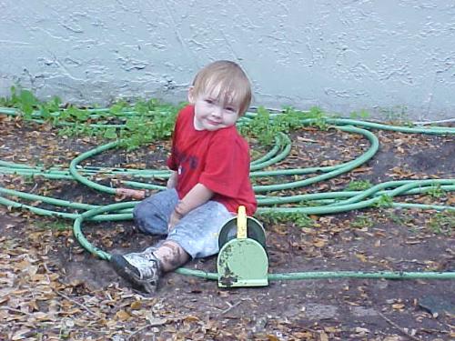 My son playing in the mud  - This was taking a few weeks ago my husband was watering the front yard and my son was having a blast playing in the mud. My husband came in the house and told me I had to get a picture of him. I came out and this is one of the three shots that I snapped of him.