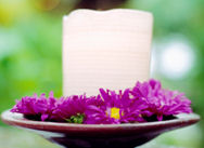 Candle - stock photo of a candle with purple flowers arranged around it