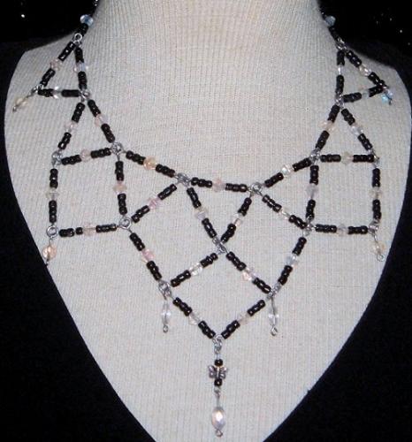 Necklace - This is a necklace I designed for myself. It's made of stainless steel wire, clear glass aurora borealis beads and black glass seed beads. There is also a pewter butterfly charm in the bottom center. I also made earrings to match.
