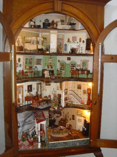 Miniature Display in cabinet - Someone used this cabinet to set a miniature display in lieu of an actual dollhouse. I think it's awesome! Each level is intricate and creative.