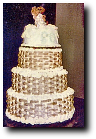 Anniversary Cake - This is a cake I made for a couple who were celebrating 60 years of marriage! I made the sides of the cake to look like basketweave, so that the layers would look like baskets stacked on top of each other. This is a scan of a poloroid picture, so the quality isn't great but at least I have a picture of it.  We were trying to save a little money with it, so we went to the dollar store and found this cute dancing bear couple to put on top of the cake.   It was lots of work and since this was made on a very hot day in the middle of the summer, it's a wonder it made it to the party in one piece. But it survived beautifully and the party was a big success!