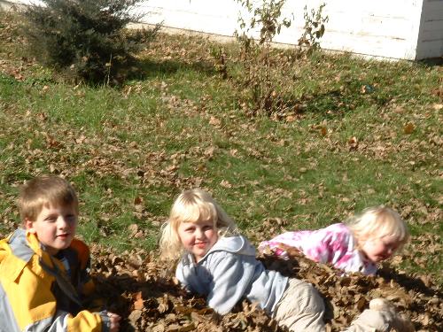 trying to pose for Mom - My three kids playing in the leaf pile. Do you think they could all look at the camera at the same time?