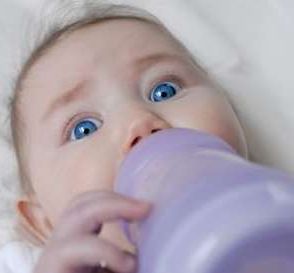 Help, I need more food! - Baby holding a milk bottle.