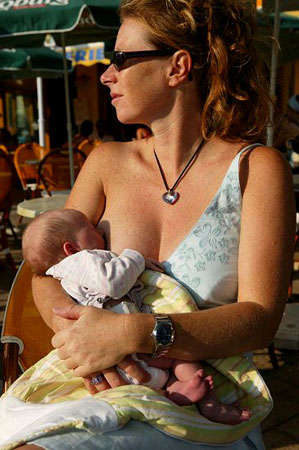 Public Breast feeding - Lady breastfeeding her baby in public.