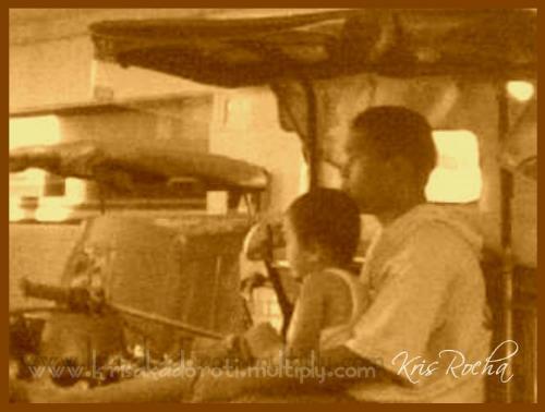 father and son - this is a stolen shot of a father and son (from Philippines). i took this shot from a moving car using a camera phone. the father is a tricycle driver. they are seated in the tricycle waiting for passengers.