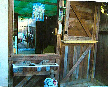 Potting Shed - This is the potting shed I built next to my garage out of old scrap wood. The ceiling panels were donated by a friend, and all the framing wood was stuff that I collected over a couple of years. The 'Siding' is made from my neighbors old fence...he gave me the boards as he was putting up his new one...  The door was an accident of sorts..because I didn't think I would have enough wood to make a whole door...so I only made the bottom of it. But realized later that I still had some left, so I made the top half later...  I made a door bell for it too, and a friend carved the sign for me out front...'JP's Flower Shop'...Cute, huh?