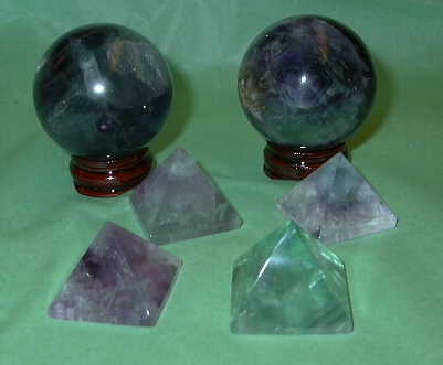 Fluorite Spheres & pyramids - Fluorite is the ultimate stone of Well Being. It provides purification, cleansing, and eliminates that which is in disorder. It works within the physical, emotional, and spiritual systems, bringing a sense of calmness and peace. It's multi-colors enhance all aspects of well being, notably the purples for wisdom and intuition, and the greens for healing and abundance.