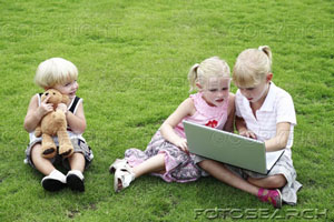 Children with laptop and toy bear - Children are also very much interested in surfing the net.Now a days ther are so many sites on the internet which provides comics,games ,rhymes and toys for the children so children also enjoy surfing the net
