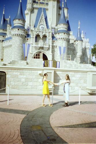 disney - My daughter (dressed in yellow) at Disney in front castle.