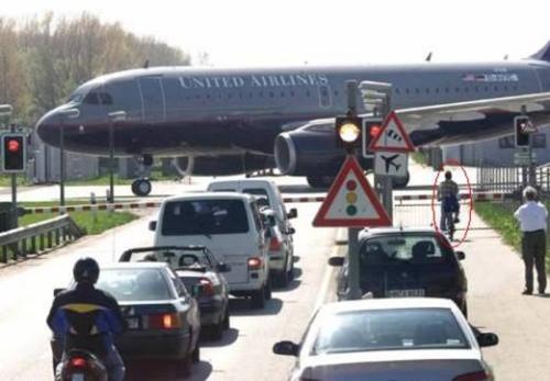 Aircraft crossing - We have seen railway crossing but do you know about Aircraft crossings ? In Germany and Thailand you can see the public roads which cross the Taxi path of Aircrafts. These are not Run ways but only Taxiing route of Aircrafts