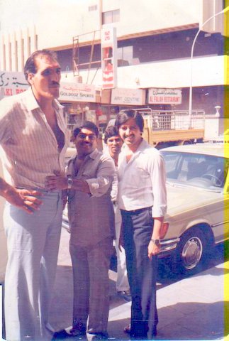 Photo with George - from James Bond Movie - What a - While in Dubai, I met Mr. George [He is from James Bond Movie] My height is 5' 6 1/2 '.  I seem to to be a lilliputian, in front of him. He must be at least 7' [ I am not very sure of his height though ] It seems that his biceps are bigger than even my thighs [ ? ] Wow what a height. His car seat was especially pulled back so that he is comfortable while he is driving. What more, he seemed to almost touch his hand with ease to the ceiling of our shop, even without raising, it fully. G R E A T G E O R G E.
