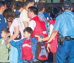 hostage taking - Children are taken away by police officers and their parents following their release after being held captive in a bus for 10 hours in Manila yesterday. – Photo By MIKE AMOROSO 
 
 
