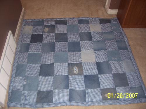 Nephew's quilt  - This is a quilt I made for my nephew for Christmas '06. The levi's are from old jeans from me and my Dad. The blue gingham is from material my nephew had chosen months before, not having any idea why he was picking it. It was a really fun quilt to make! I stitched his name into the back with one of the fun stitches on my machine. I also added a design around two of the edges on the back to keep the batting intact with the one layer. He absolutely loves this quilt and sleeps with it every night!