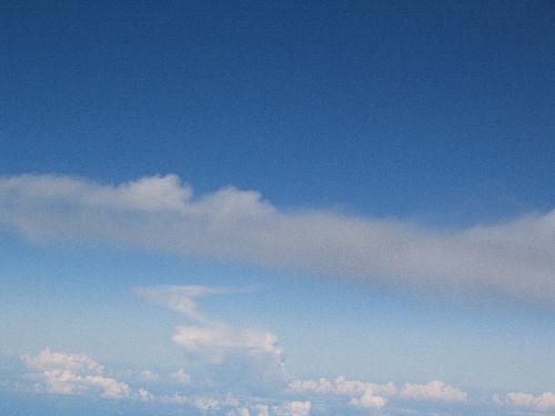 Blue Sky - beautiful picture of the sky. I love to take pics of the sky when I fly. The soft puffy white clouds floating dreamily on the blue background.  It is simply breath taking! This is especially beautiful on a clear day.  With lots of clouds floating around, it really takes on a fantasy feel.