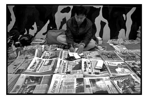 Daily news - Near jalan braga in Bandung theyre is a place were you can get the paper before everyone else. This place is were the people that are usually selling it to you actually buy it. It looks more like a flee market but all with newspapers and magazines. The guy on the picture is on the sidewalk but if you turn around theyre is a parking lot full of other resellers. Some even asked me in wich newspaper theyre picture would appear.....