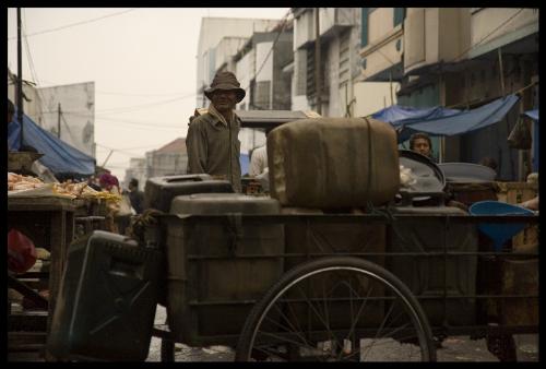 gaze at the old market - I took this picture at the pasar baru traditional market. It was still early in the morning. The guy on the picture is pedicab driver . He is waiting for custommers in need for a ride.