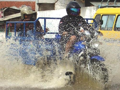Flood Cruiser - Cruising a street flood in Bandung, West Java, Indonesia.   This modified motorcycle is used to carry some stuff from groceries store.
