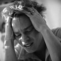 Teenage Depression - Picture of a young man holding his head in his hands.