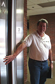 man holding door open - This is a picture of a man holding an elevator door open for someone.