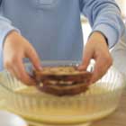 cooking - A sandwhich being dipped in an egg mixture before being grilled.